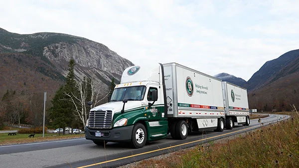 ODFL less-than-truckload trailer driving through a mountain pass, representing North American freight services.