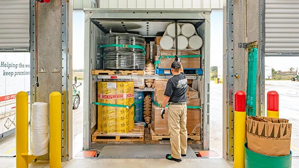 ODFL worker inspecting a fully loaded freight trailer at the dock before shipment.